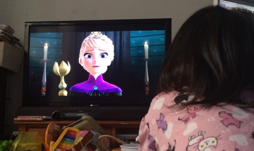 Criança assistindo o filme Frozen na televisão de sua casa. (Foto: Reprodução)