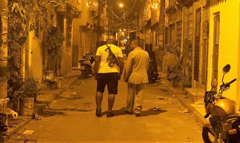 Pastor André Assis caminha ao lado de traficante no Complexo da Maré, no RJ. (Foto: ALAN LIMA - El País)