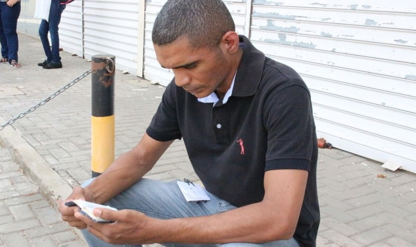 Maxshuell Vander Alves lê sua Bíblia antes de entrar para fazer a prova do Enem, em Teresina. (Foto: Arthur Ribeiro - G1)