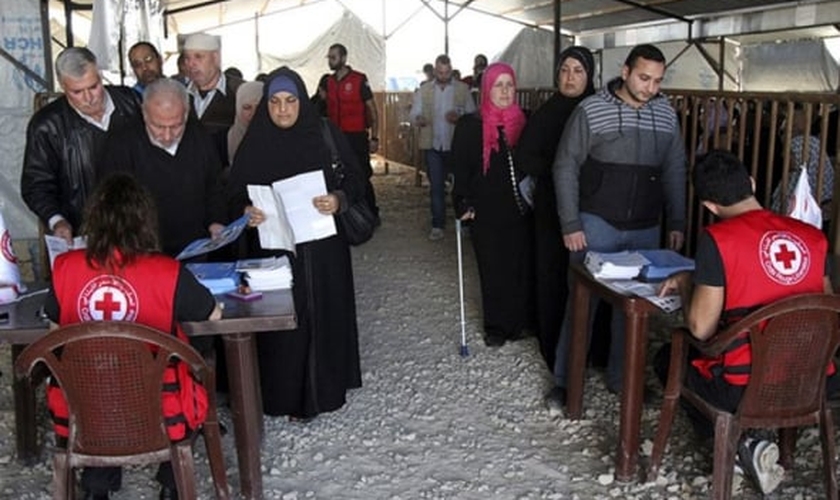 Refugiados sírios recebendo ajuda da agência de refugiados da ONU em Trípoli, no norte do Líbano. (Foto: Reuters/Omar Ibrahim)