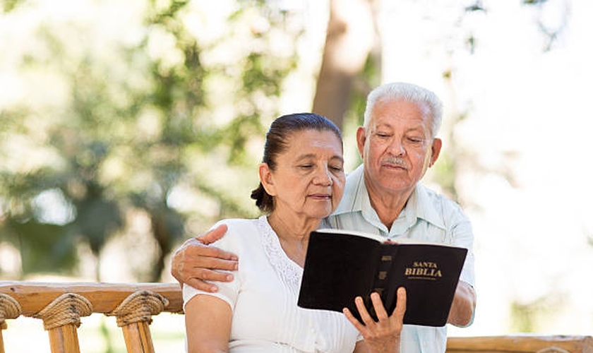 Imagem ilustrativa. Casal de idosos lendo a Bíblia Sagrada juntos. (Foto: Aldo Murillo/Captura/iStock)