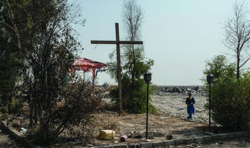 Cruz erguida em uma praça da cidade de Karemlash, no Iraque, devastada por militantes do Estado Islâmico. (Foto: Martyn Aim)