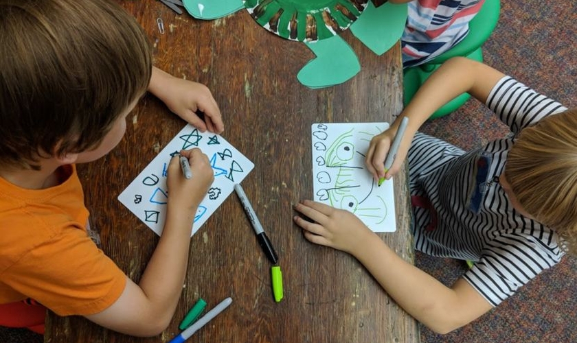 Crianças do jardim de infância desenham em atividade escolar. (Foto: Ktoo)