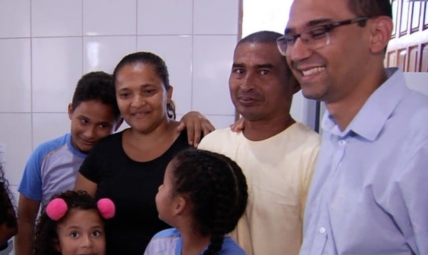 Ao lado dos filhos e do diretor da escola, casal se emocionou com nova casa. (Foto: Reprodução/TV Anhanguera)