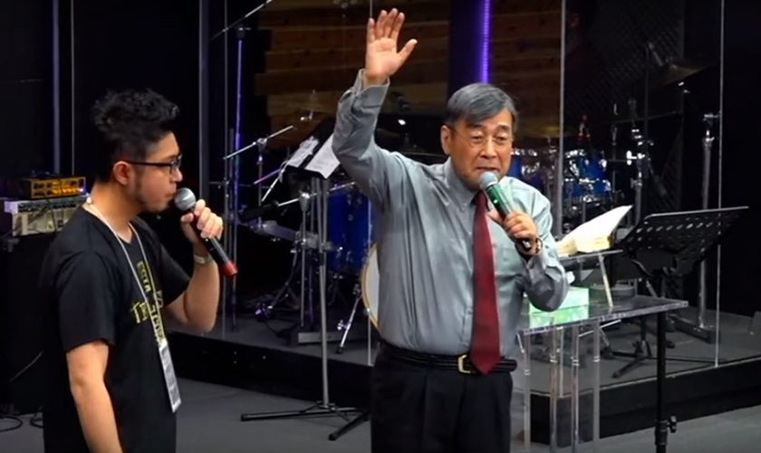 Pastor Hiraoka Shuuji (direta) alerta para a urgência de um movimento missionário no Japão. (Foto: YouTube/Reprodução)