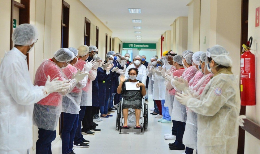 Mulher deixa hospital sendo aplaudida por equipe médica no Amazonas. (Foto: G1)