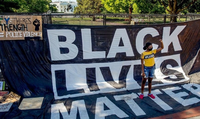 Militante faz posição sinalizando gesto símbolo do Black Lives Matter em protesto nos EUA. (Imagem: Fox News)