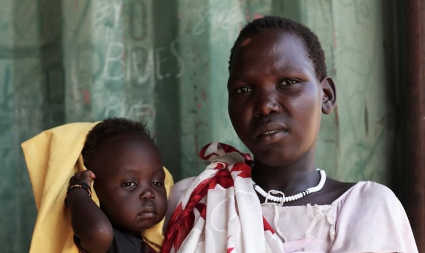 Nyamuot Joak segura sua filha de um ano, que sofre de desnutrição e está sendo tratada em uma clínica cristã no Sudão do Sul. (Foto: Andreea Campeanu/DEC)