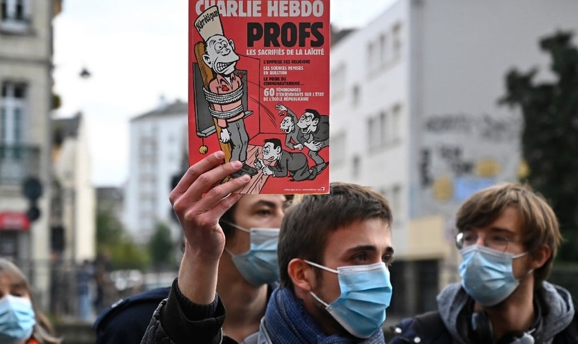 Manifestante segura capa do Charlie Hebdo, um dia após o professor ter sido decapitado na França. (Foto: Damien Meyer/AFP)