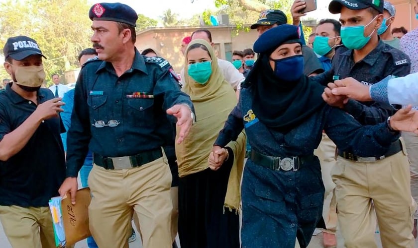 Policiais escoltam a adolescente paquistanesa Arzoo Raja, após sua aparição no Tribunal Superior de Sindh, em Karachi, Paquistão, no dia 3 de novembro de 2020. (Foto: AP Photo/Fareed Khan)