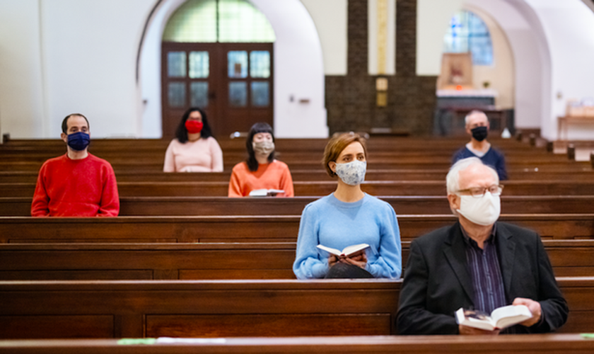 Fiéis em igreja usando máscaras e mantendo distanciamento social. (Foto: Luis Alvarez/Getty Images)