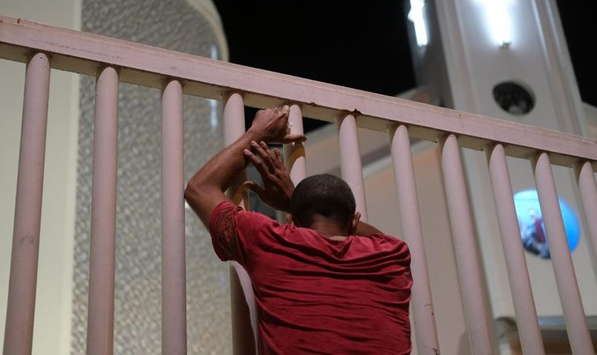 Homem do lado de fora de igreja fechada no Rio de Janeiro. (Foto: Ricardo Moraes/Reuters)