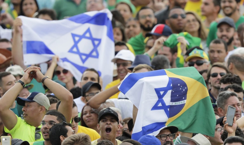 Brasileiros seguram a bandeira de Israel. (Foto: Silvia Izquierdo/AP)