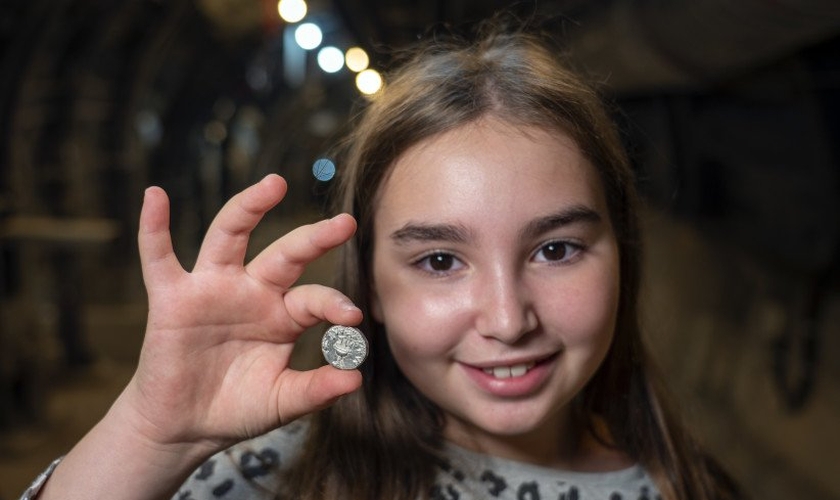 Liel Krutokop, de 11 anos, com a moeda que encontrou. (Foto: Yaniv Berman/Cidade de Davi e Autoridade de Antiguidades de Israel)