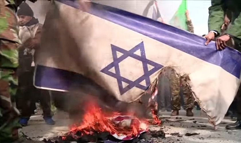 Bandeira israelense sendo queimada por iranianos. (Captura de tela: YouTube/City News)