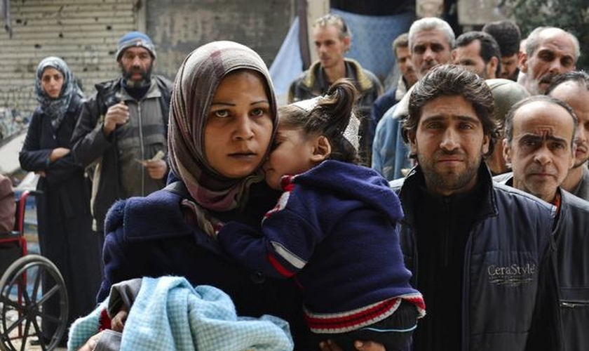 Palestinianos e sírios deixam o campo de refugiados em Yarmouk