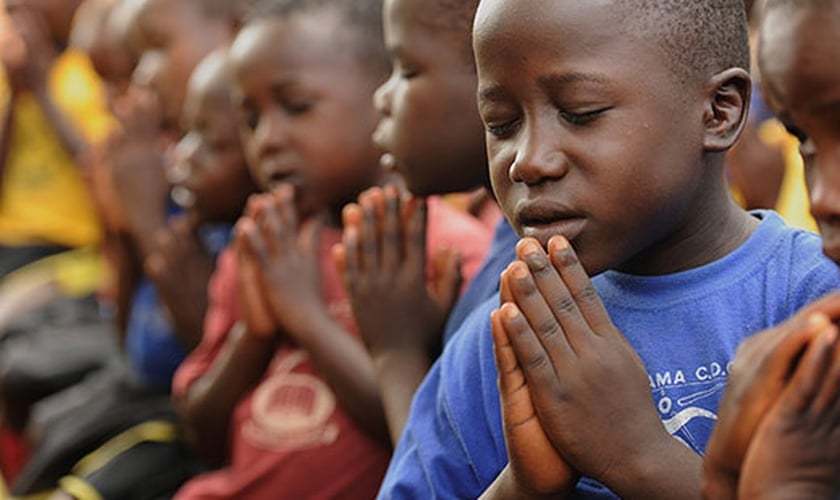 Crianças de Uganda orando. (Foto: Compassion)