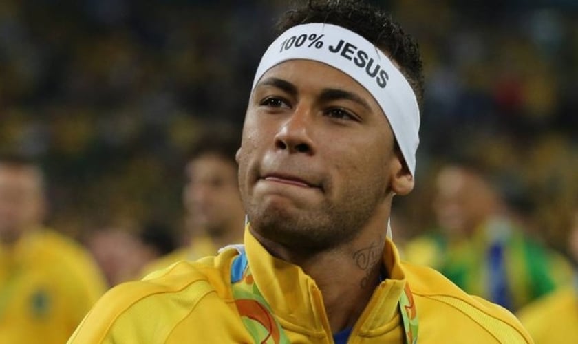 Neymar desafiou uma regra da 'Carta Olímpica' e exibiu a faixa com a expressão '100% Jesus' durante a premiação olímpica da Seleção Brasileira de Futebol Masculino. (Foto: João Laet / Globo)