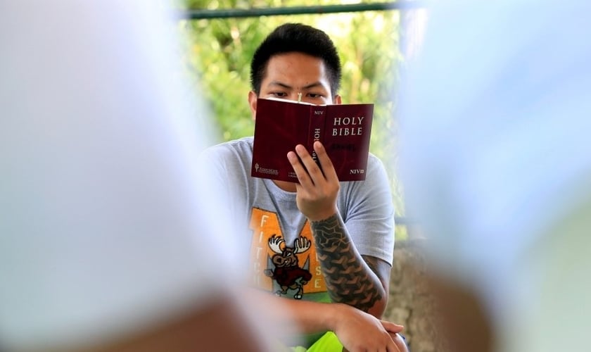 Jovem lendo a Bíblia. (Foto: Reuters)