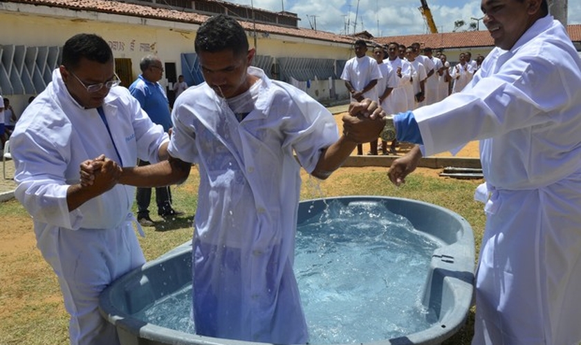 Com ajuda de pastores, presos são batizados numa caixa d'água. (Foto: Andréa Tavares/G1)