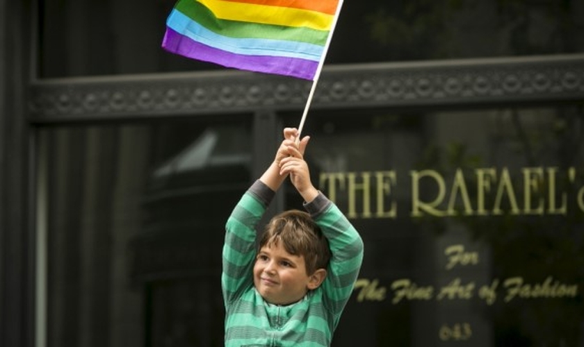 Garoto segura bandeira do movimento LGBT. (Foto: Reuters)