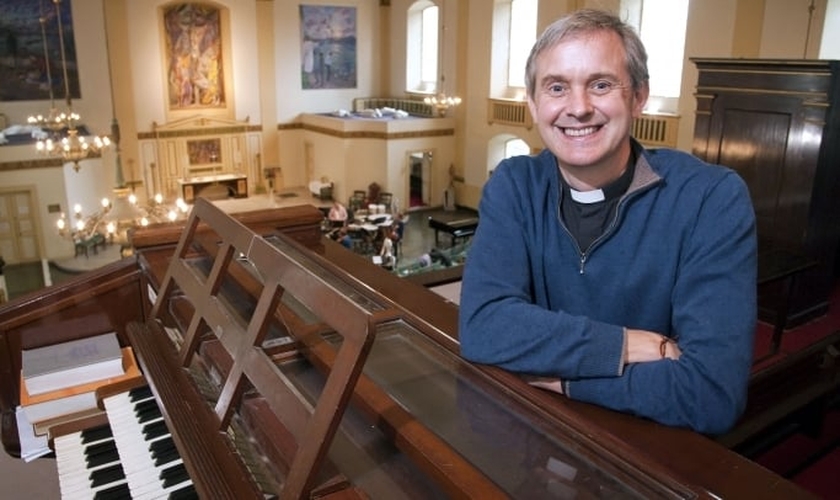 O vigário Canon Godard lidera atualmente a igreja de St. John (Igreja da Inglaterra), em Waterloo (Londres).