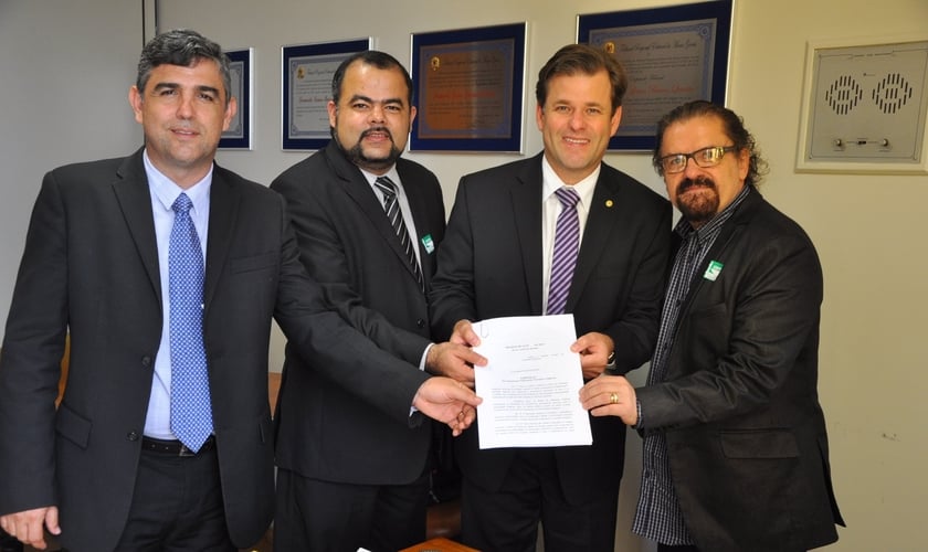 Dr. Jonas Moreno (Diretor de Assuntos para Refugiados e Ajuda Humanitária da ANAJURE), Dr. Uziel Santana (Presidente da ANAJURE), Deputado Federal Leonardo Quintão (Presidente da Frente Parlamentar Mista para Refugiados e Ajuda Humanitária da ANAJURE) e A