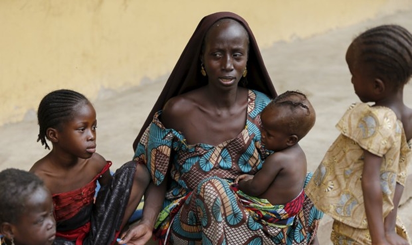 Mulher resgatada do Boko Haram alimenta um de seus filhos no campo de refugiados, na Nigéria.