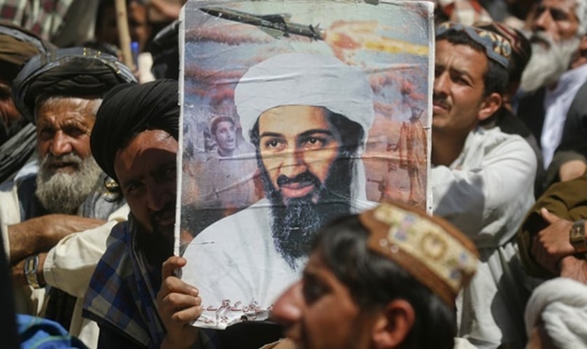 Apoiador do grupo extremista paquistanês 'Jamiat-e-ulema-e-Islam' segura cartaz com foto do ex-líder da al-Qaeda, Osama bin Laden, durante manifestação contra a ação dos Estados Unidos no Oriente Médio