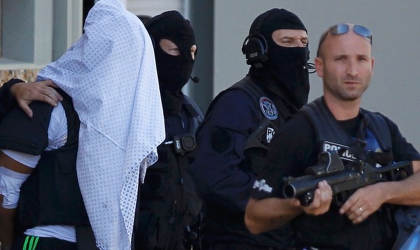 Com a cabeça coberta por uma camisa, Yassin Salhi é levado pela polícia francesa