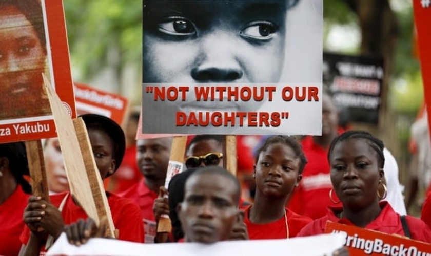Familiares e amigos participam de manifestação, clamando pelo resgate das meninas sequestradas pelo Boko Haram em 2014, segurando placas como esta, que diz "Não sem nossas filhas"e com o lema "Tragam nossas garotas de volta" (Foto: Reuters)