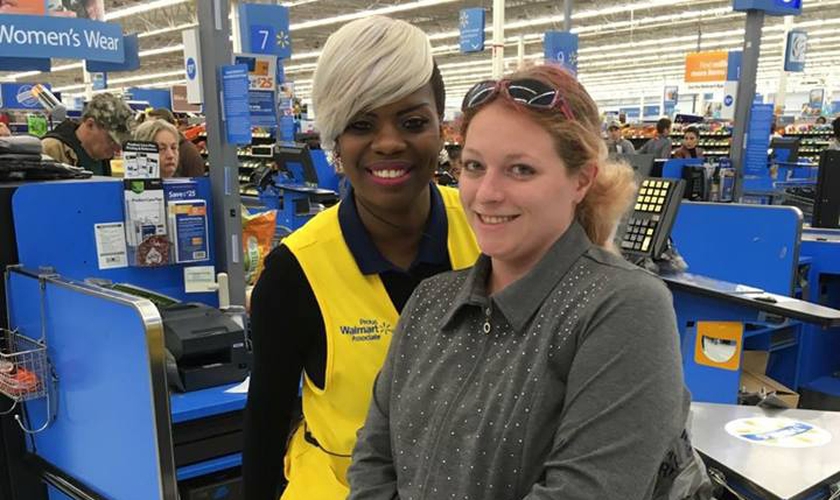 A funcionária Sharnique Dasant ao lado da cliente Ashley Jordan, em frente ao caixa do Walmart. (Foto: Reprodução/Facebook)