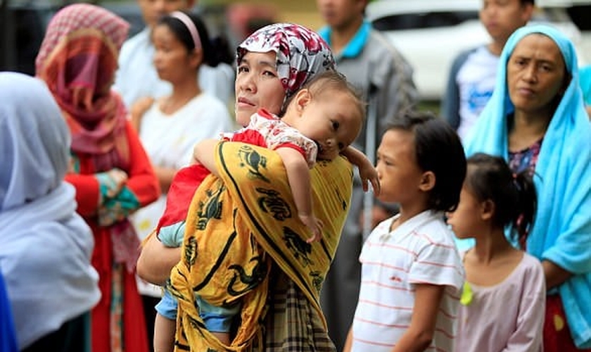 Mãe segura seu filho em meio ao caos instalado nas Filipinas, após cerco de terroristas. (Foto: Reuters)