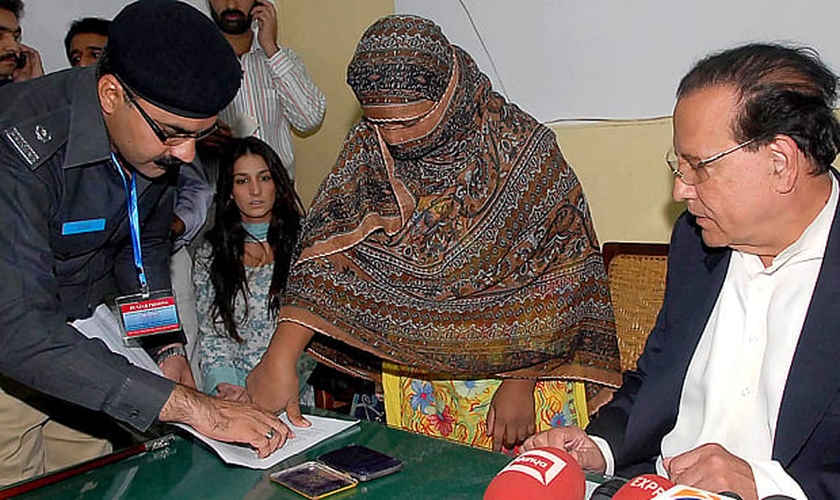 Asia Bibi coloca sua digital em um documento de recurso contra a condenação de sentença de morte. (Foto: AFP)