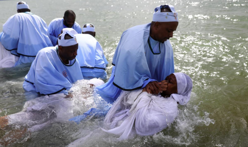 Os membros da igreja de Muchinjikwa são batizados na praia de Southend. (Foto: Reprodução/Reuters).
