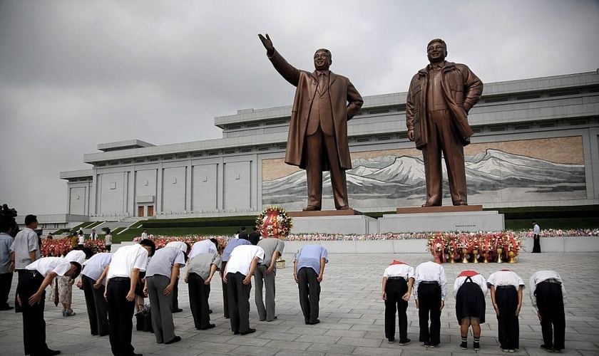 Norte-coreanos curvam-se diante das estátuas de bronze dos falecidos líderes Kim Il Sung e Kim Jong Il no Grande Monumento da Colina Mansu. (Foto: AP)