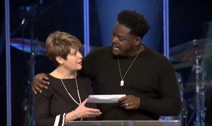 O pastor Derwin Gray entrega doação para Julie Walters, do Centro de Enriquecimento das Mulheres. (Foto: Reprodução/Facebook)