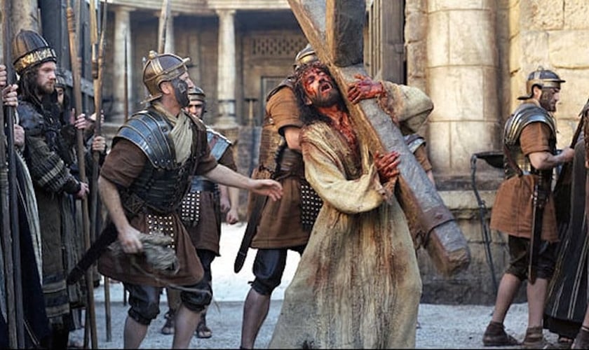 Jesus (Jim Caviezel) carrega a cruz no filme A Paixão de Cristo. (Foto: Reprodução/Icon Productions)