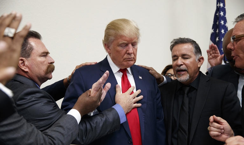 Pastores oram por Donald Trump durante visita à Igreja Internacional de Las Vegas e à Academia Cristã Internacional. (Foto: Evan Vucci / AP)