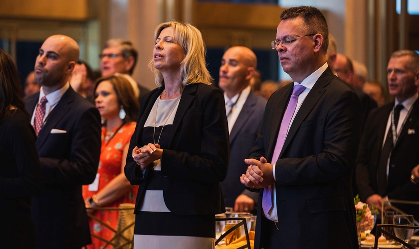 Pastor Andrew Brunson (primeiro plano à direita) e sua esposa Norine (primeiro plano do centro) oraram com líderes em um jantar de 1º de maio, antes do Dia Nacional de Oração. (Foto: Reprodução/John Phillips)