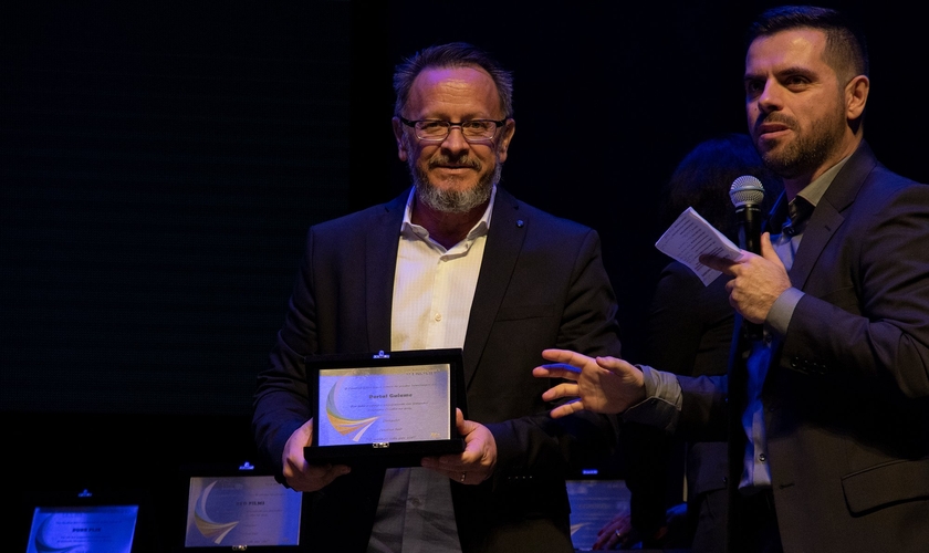 Marcos Corrêa, diretor do Guiame, segura placa em homenagem à atuação do portal. (Foto: Guiame/Marcos Paulo Corrêa)
