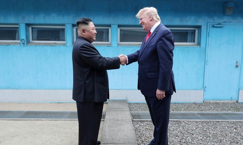 Trump em aperto de mãos com Kim na linha de demarcação que divide as duas Coreias. (Foto: KCNA via Reuters)