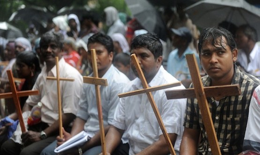 Cristãos seguram cruzes como símbolo de sua fé. (Foto: Reprodução/AFP)