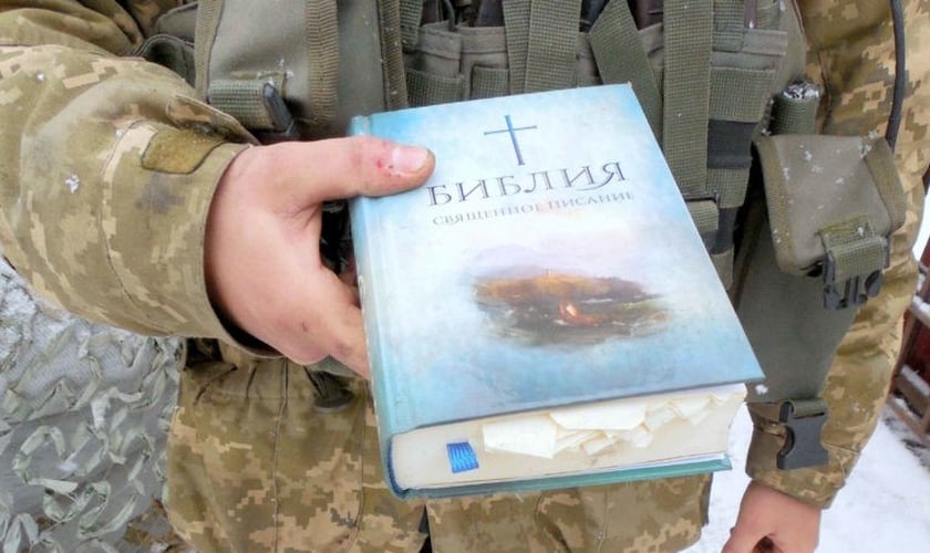 Policial segura uma Bíblia. (Foto: Reprodução/Mission Eurasia)