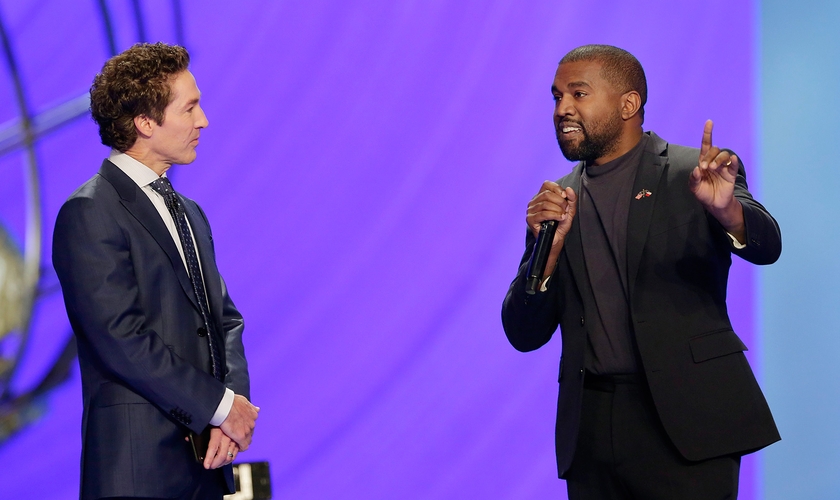 Kanye West ao lado do pastor Joel Osteen (à esquerda), durante um culto na Igreja Lakewood. (Foto: AP/Michael Wyke)