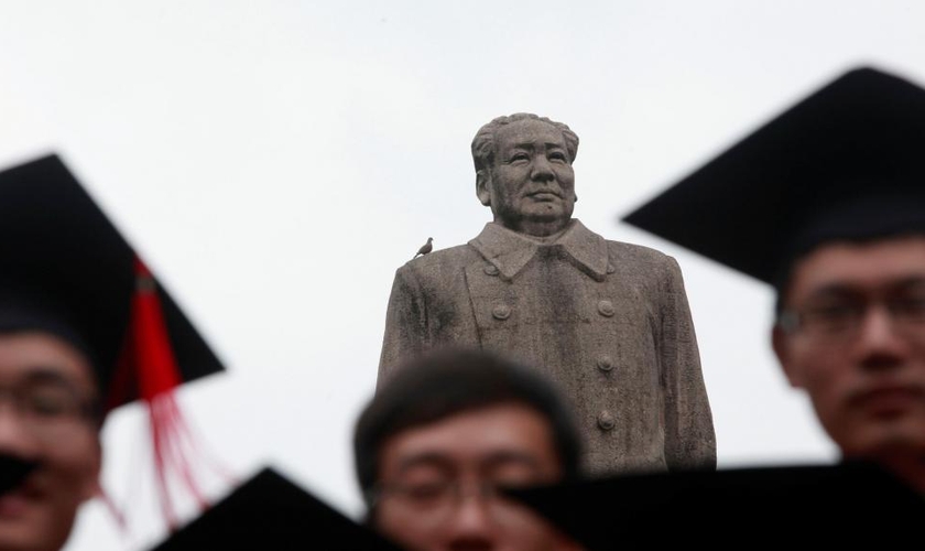 Graduados posam para foto em frente à estátua do líder chinês Mao Tsé Tung após sua cerimônia de formatura na Universidade de Fudan, em Xangai. (Foto: Aly Song/Reuters)