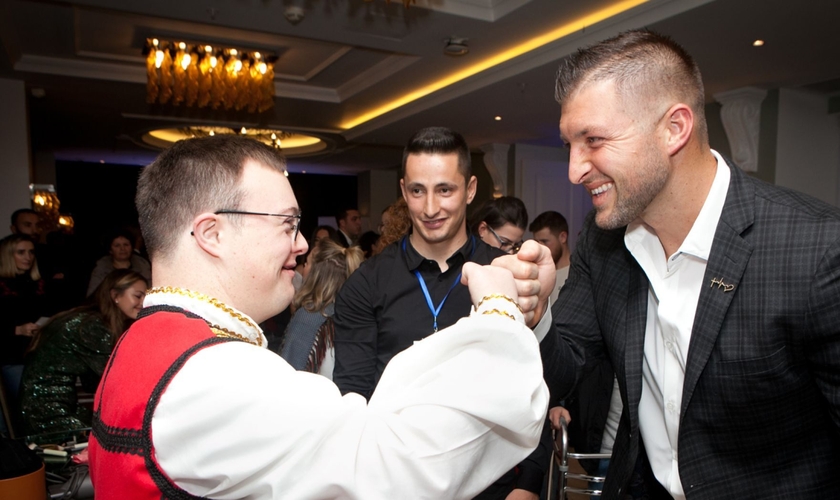 Tim Tebow cumprimenta um convidado na "Night to Shine", na Albânia. (Foto: Reprodução / Fundação Tim Tebow)