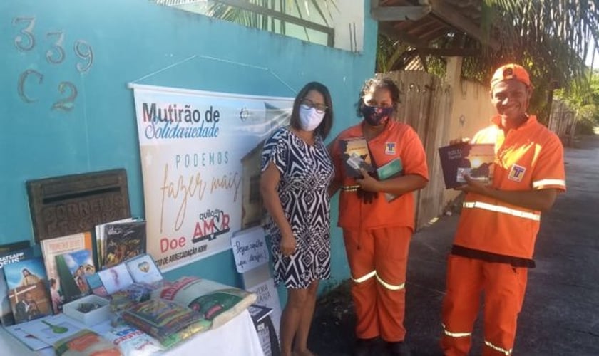 A mesa solidária despertou a atenção de dois profissionais de limpeza urbana que quiseram pegar livros religiosos. (Foto: Arquivo pessoal)