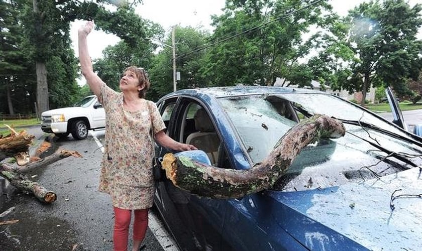 Debby Clish aponta para o céu em agradecimento a Deus, após se livrar de um acidente nos EUA. (Foto: Marc Vasconcellos/The Enterprise)
