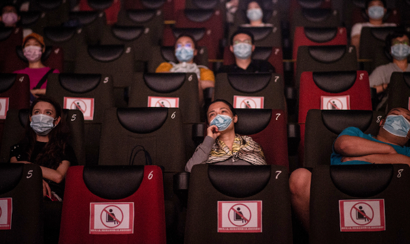 As pessoas assistem a um filme no dia 20 de julho, no primeiro dia da reabertura dos cinemas chineses em Wuhan, na província de Hubei. (Foto: Reprodução / AFP)